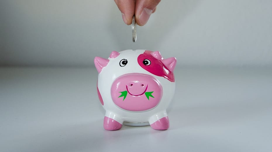 putting a coin in a piggy bank